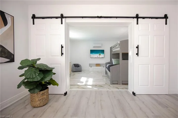 Hall featuring a barn door, entrance to the despecious den/kids' playroom