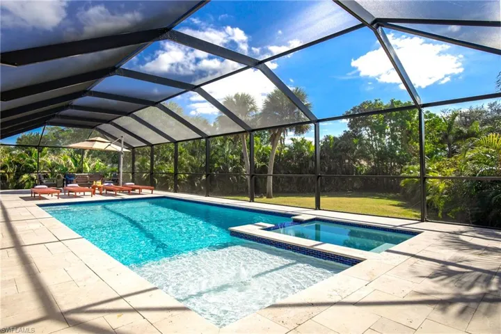 View of pool with connected hot tub featuring an amazing lanai