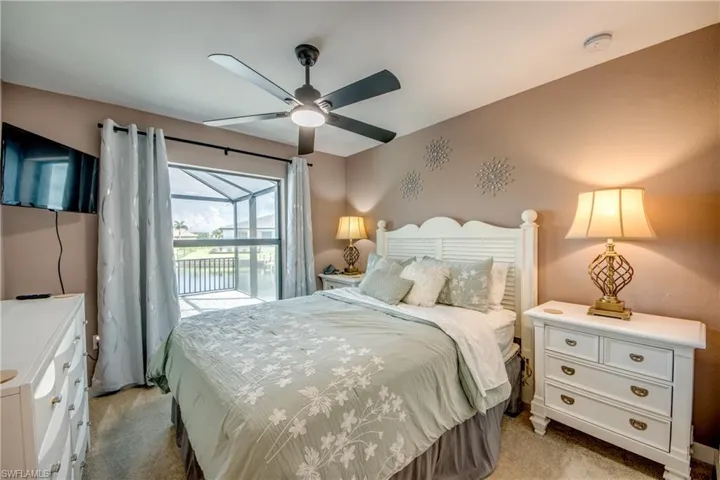 Bedroom with light carpet, access to exterior, and ceiling fan
