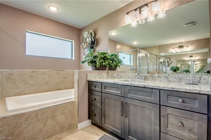 Bathroom featuring tile patterned flooring, double vanity, and a shower with curtain