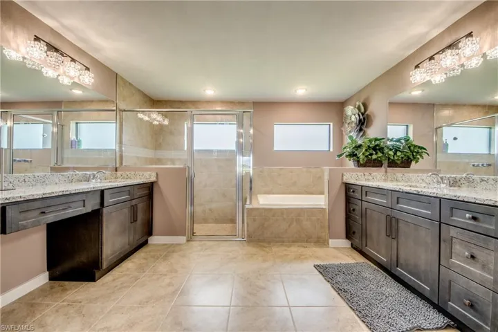 Kitchen with a raised ceiling, light stone counters, open floor plan, ceiling fan, and recessed lighting