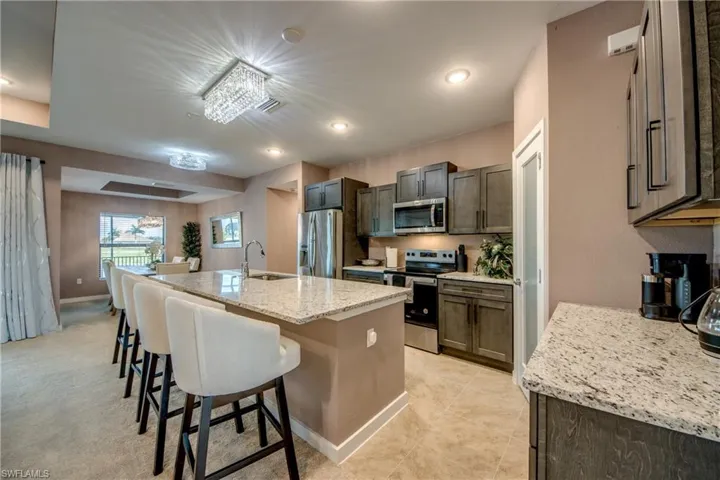 Kitchen featuring appliances with stainless steel finishes, light stone counters, recessed lighting, and light tile patterned floors