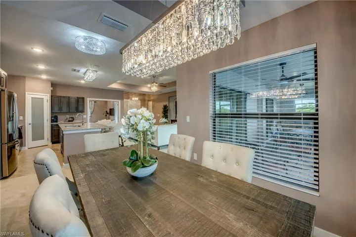 Dining area featuring a tray ceiling, light carpet, and a chandelier