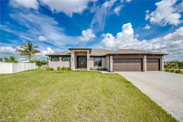Prairie-style house featuring stucco siding, a garage, decorative driveway, and a shingled roof
