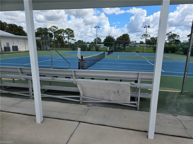 Dual tennis courts featuring blue and green playing surfaces, surrounded by chain-link fencing