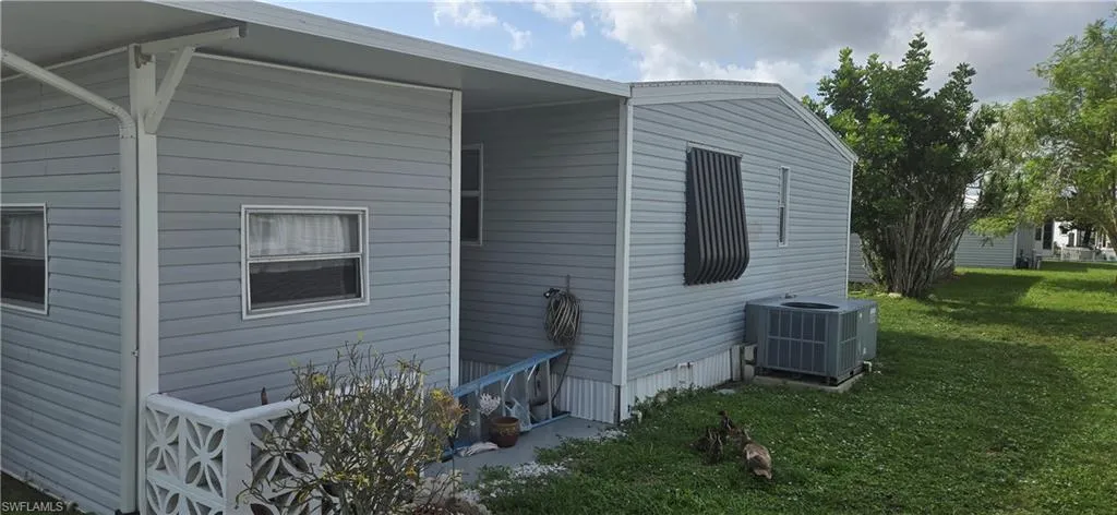 Gray horizontal vinyl siding exterior with white trim and a covered side entrance