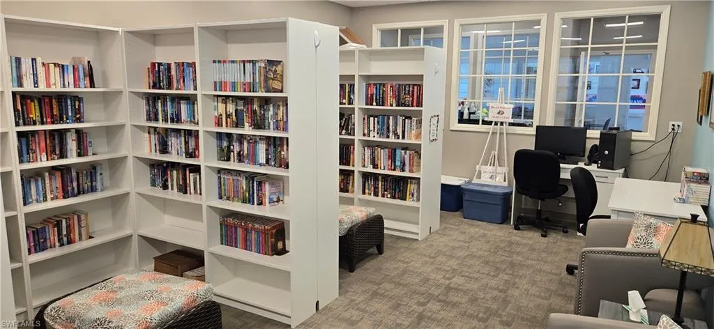 Room featuring extensive built-in white shelving units, multiple grid-patterned windows, and neutral carpeting