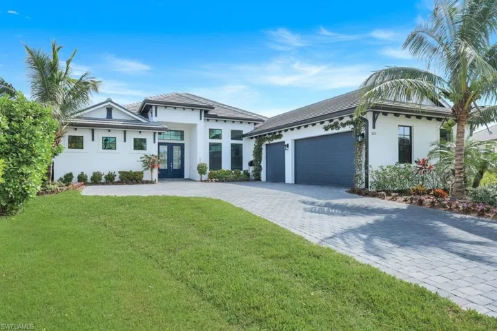 View of front facade featuring a front lawn and a garage