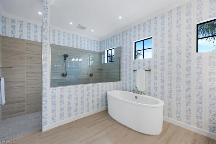 Bathroom with crown molding, independent shower and bath, and hardwood / wood-style floors