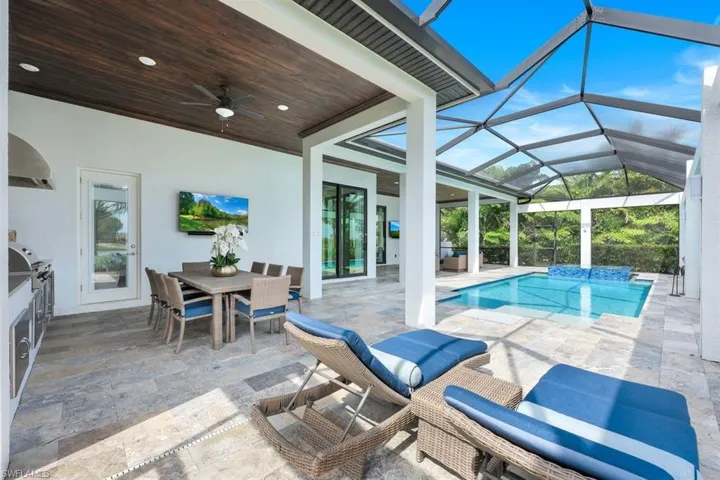 View of pool featuring ceiling fan, glass enclosure, and a patio area