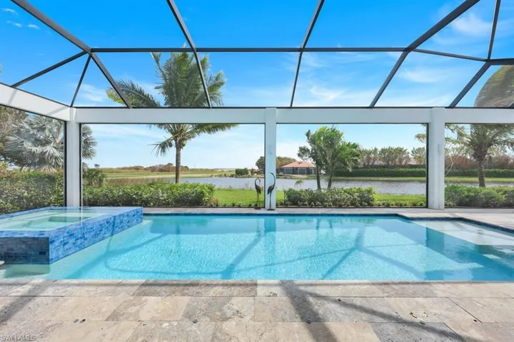 View of swimming pool with a patio, an in ground hot tub, a water view, and a lanai