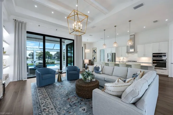 Living room with a notable chandelier, ornamental molding, and dark hardwood / wood-style flooring