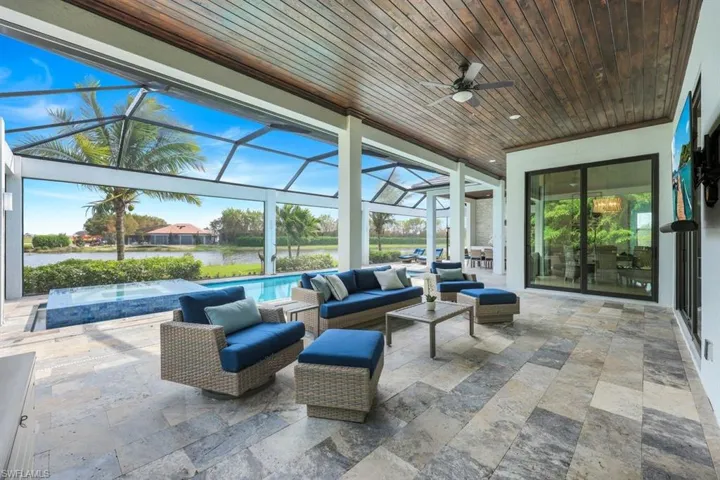View of patio featuring a water view, an outdoor living space, glass enclosure, and ceiling fan