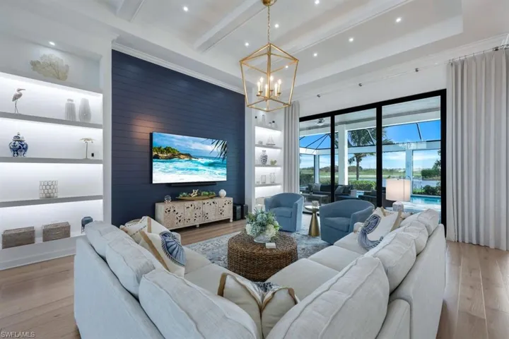 Living room featuring beamed ceiling, a notable chandelier, and light hardwood / wood-style floors