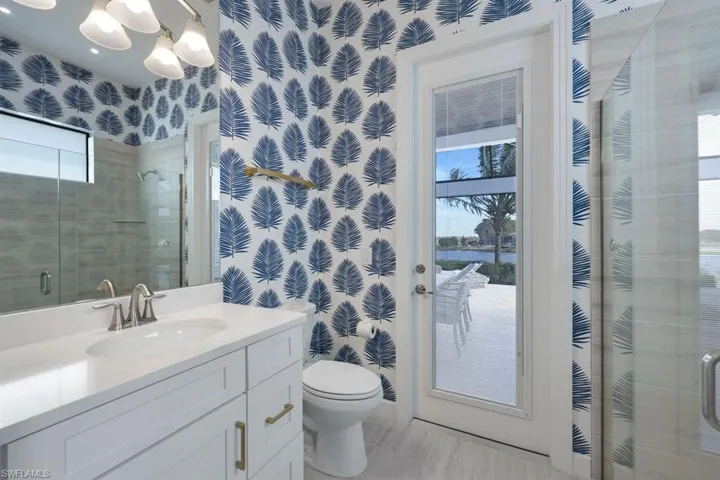 Bathroom with toilet, walk in shower, vanity, and plenty of natural light