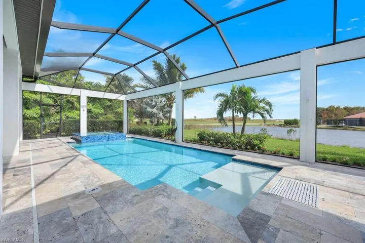 View of pool with a patio, a lanai, and a water view