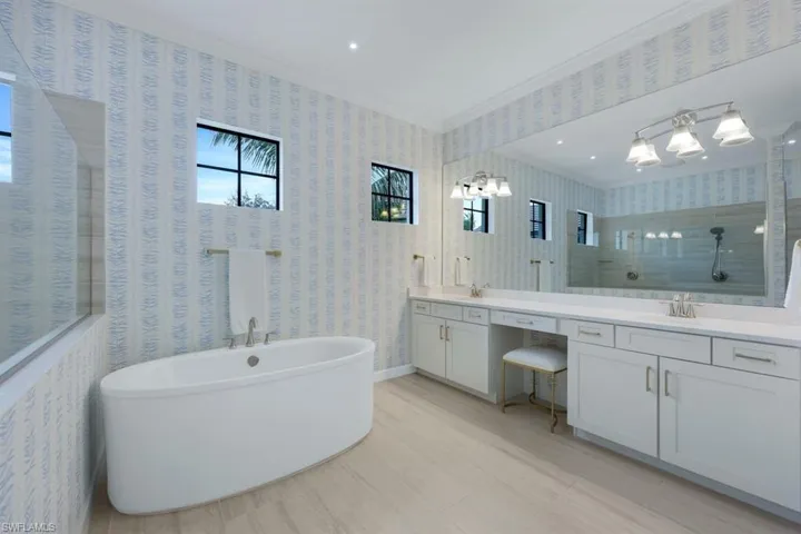 Bathroom with vanity, plus walk in shower, and ornamental molding