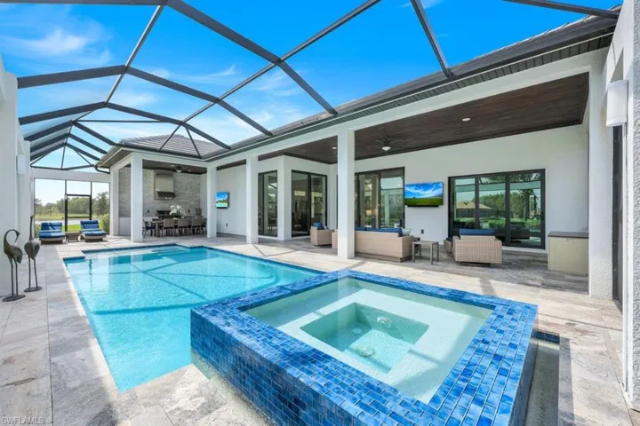 View of swimming pool featuring a patio, a lanai, an in ground hot tub, and ceiling fan