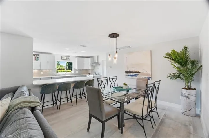 Open-concept kitchen and dining area featuring light-toned wood-finish flooring