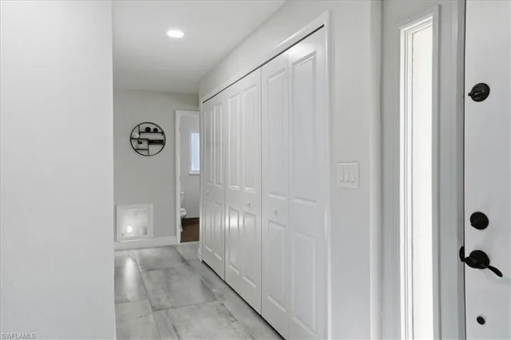 Hallway featuring large-format tile flooring and recessed lighting