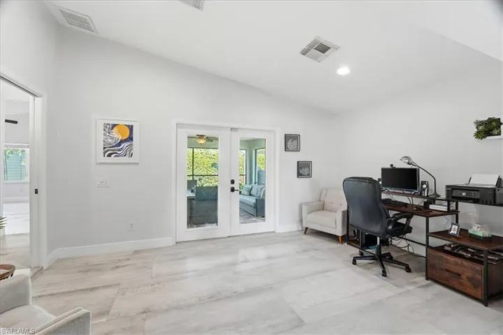 Spacious interior room featuring light-toned tile flooring, white walls, and a recessed ceiling light