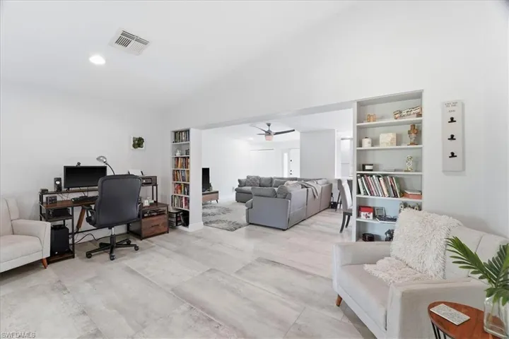 Open-concept living area featuring light-toned tile flooring and recessed lighting