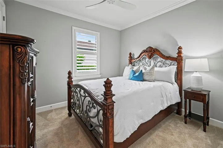 Bedroom with light carpet, a ceiling fan, and crown molding