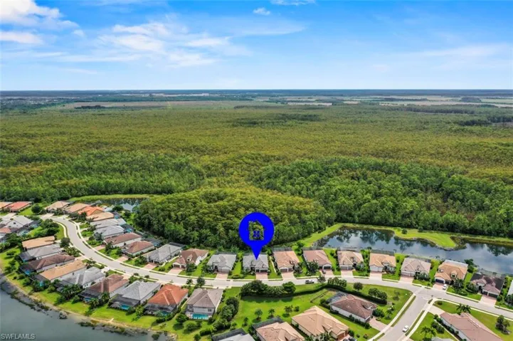 Aerial view of property and surrounding area with a nearby body of water and nearby suburban area