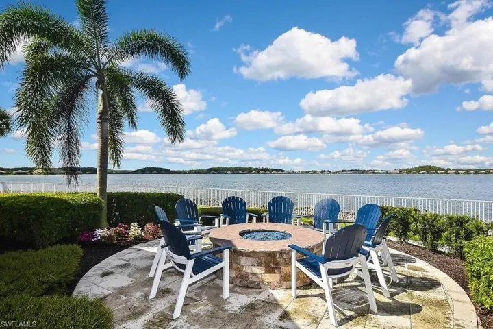 View of patio with an outdoor fire pit and a water view