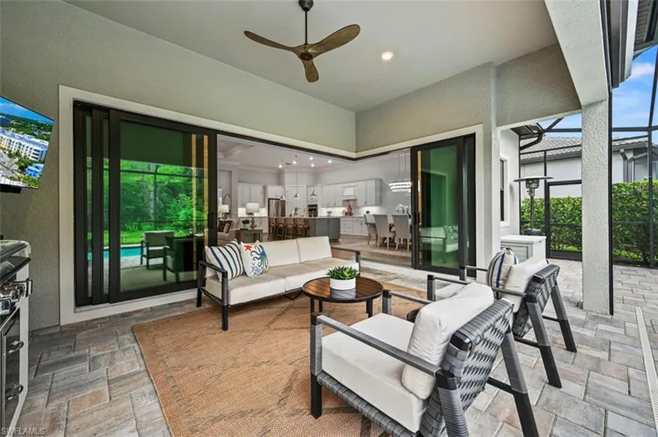 View of patio with glass enclosure, a ceiling fan, an outdoor living space, a sunroom, and area for grilling