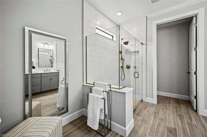 Bathroom with vanity, wood tiled floors, and a shower stall