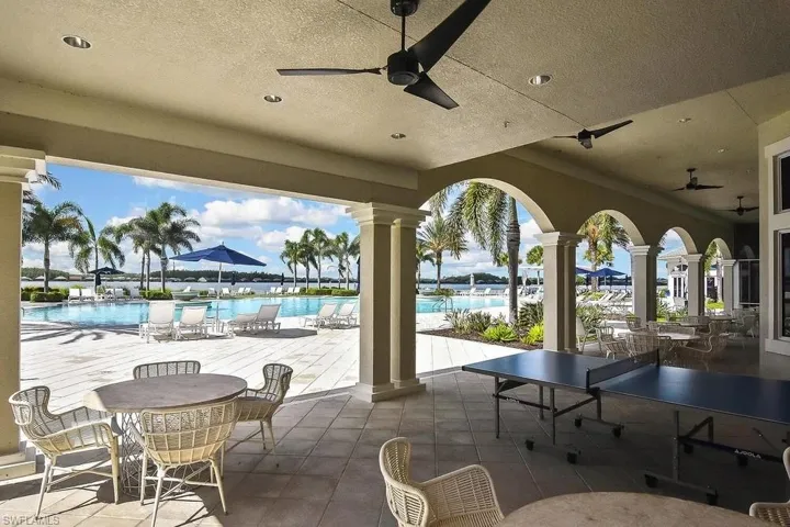 View of patio with a ceiling fan, a community pool, and outdoor dining area