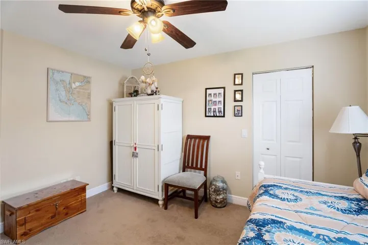 Bedroom with light colored carpet, a ceiling fan, and a closet