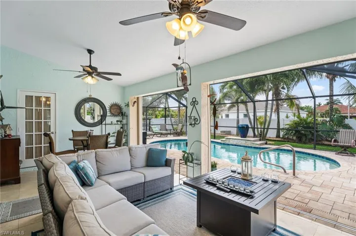 Living area featuring a sunroom, a ceiling fan, and tile patterned flooring