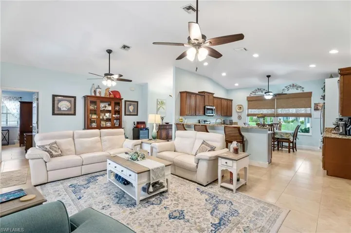 Living area with ceiling fan, healthy amount of natural light, recessed lighting, light tile patterned flooring, and vaulted ceiling