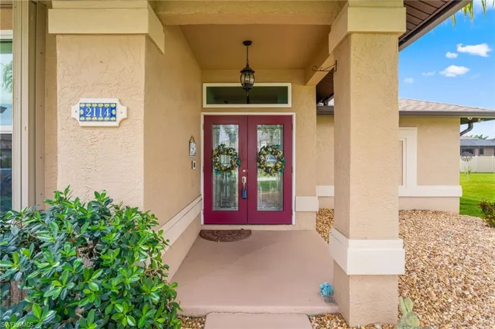 Entrance to property with french doors, a porch, and stucco siding
