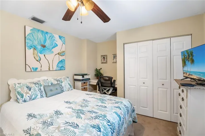 Bedroom featuring light colored carpet, ceiling fan, and a closet