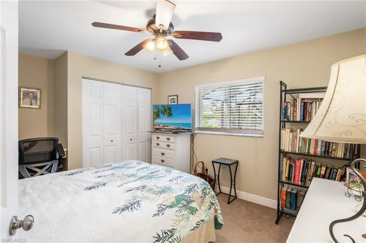 Bedroom featuring light colored carpet, ceiling fan, and a closet
