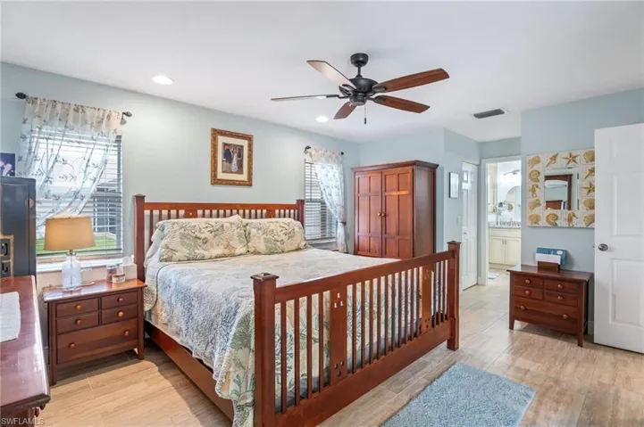 Bedroom with ensuite bathroom, a closet, light wood-style floors, ceiling fan, and recessed lighting