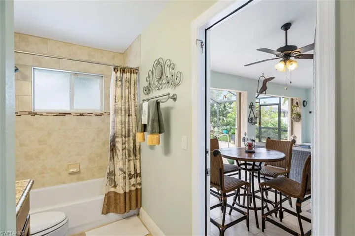 Bathroom featuring vanity, a ceiling fan, shower / bath combination with curtain, and light tile patterned flooring