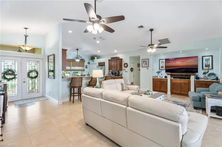 Living room featuring french doors, recessed lighting, ceiling fan, and light tile patterned floors