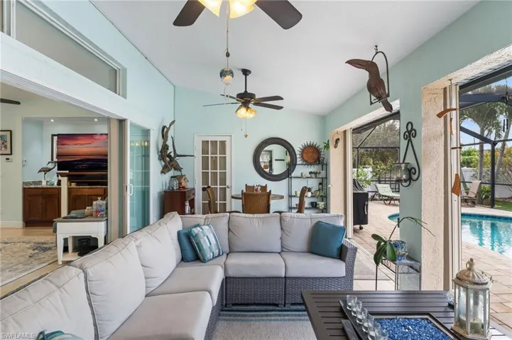 Living area with a sunroom, vaulted ceiling, and ceiling fan