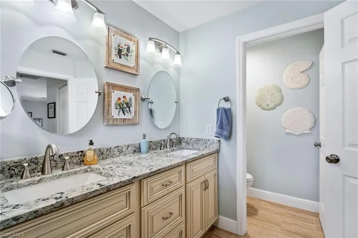 Bathroom with double vanity and light wood-style flooring