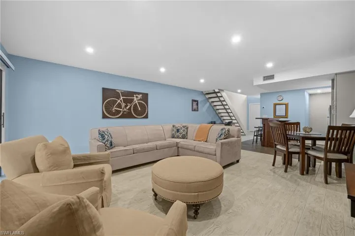 Living room featuring stairway, light wood finished floors, and recessed lighting