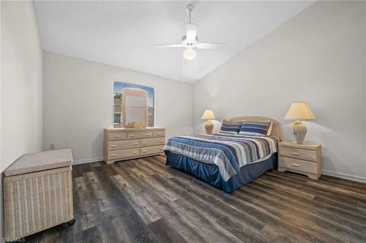 Bedroom with wood finished floors, lofted ceiling, and a ceiling fan