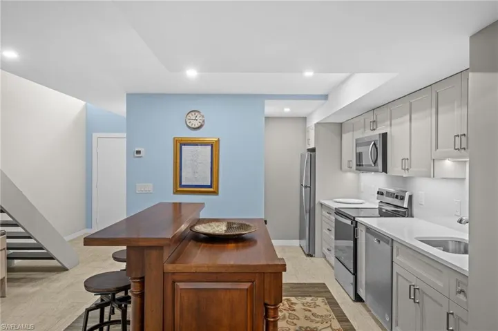 Kitchen featuring appliances with stainless steel finishes, light wood-style floors, a breakfast bar area, recessed lighting, and light countertops