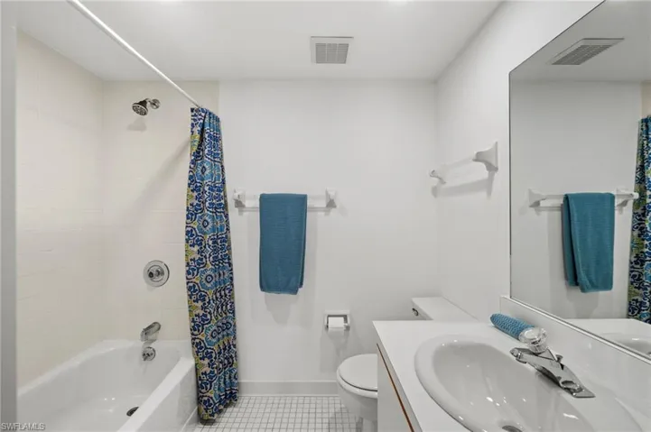 Full bath featuring tile patterned flooring, shower / tub combo with curtain, and vanity