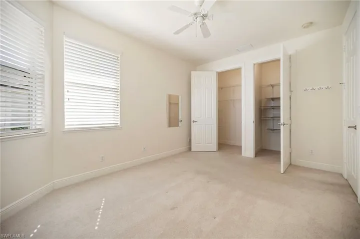 Guest room #1 featuring light carpet, a ceiling fan, and baseboards