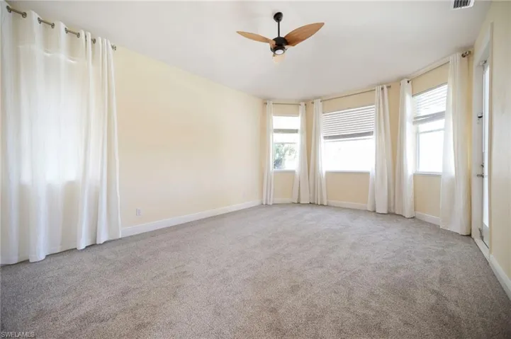 Primary Bedroom with carpet flooring, visible vents, baseboards, and ceiling fan