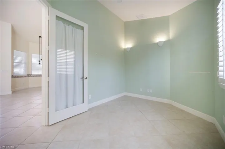Spare room with light tile patterned flooring, a healthy amount of sunlight, and baseboards